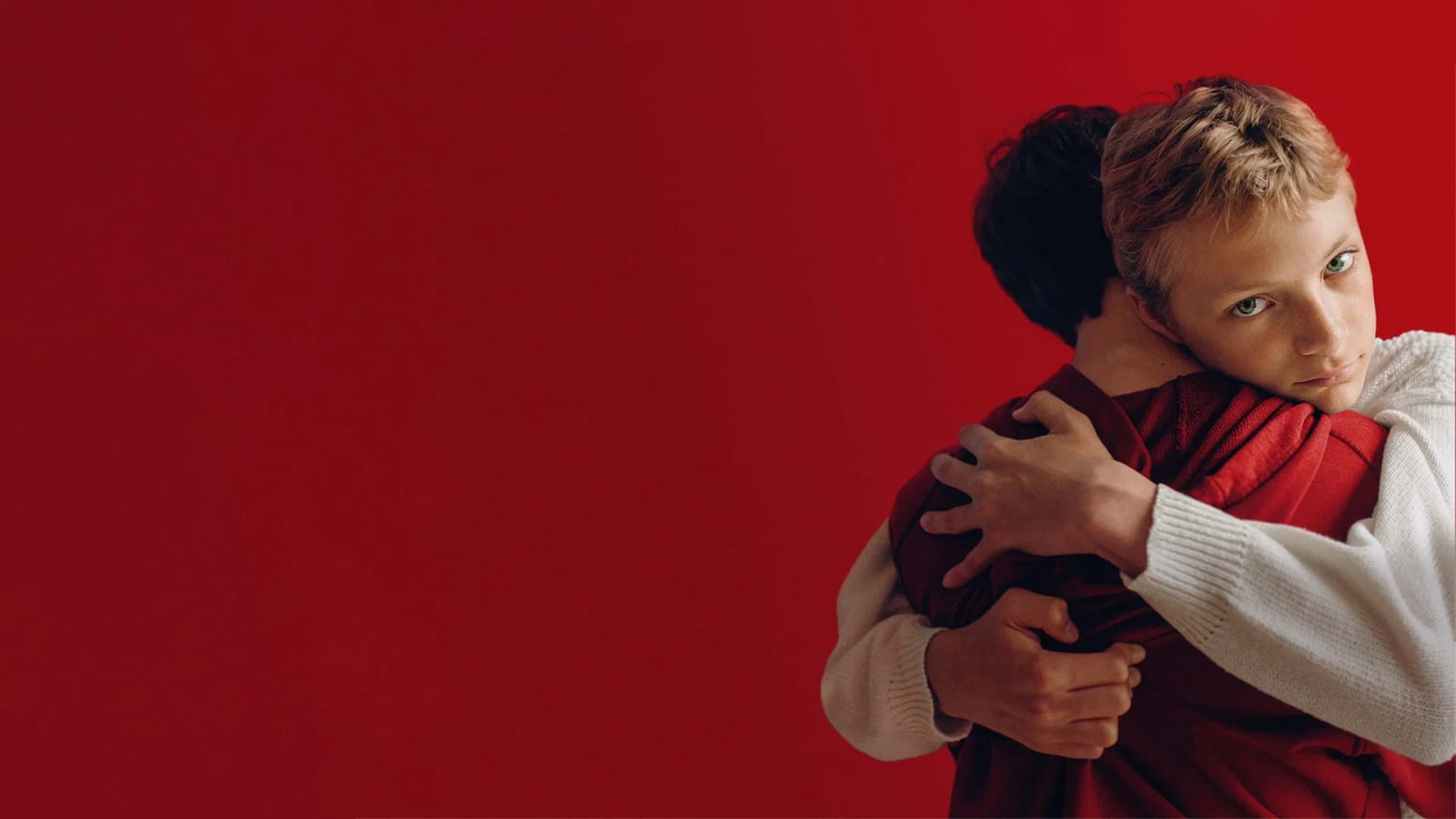 Zwei 13-jährige Jungen liegen eng umschlungen in einem Blumenfeld in Close (2022)