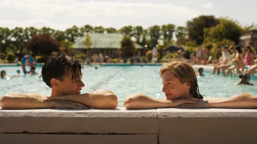 Harry Styles und David Dawson in einer Szene aus My Policeman, beide Männer in 50er-Jahre-Kleidung am Strand von Brighton