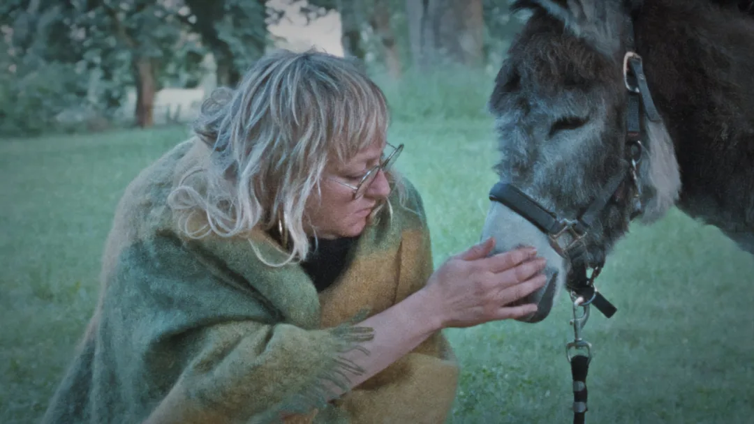 Zwei Schwestern stehen in einem norddeutschen Haus und blicken sich angespannt an, während im Hintergrund ihre Mutter wartet. Filmszene aus Donkey Days von Rosanne Pel.