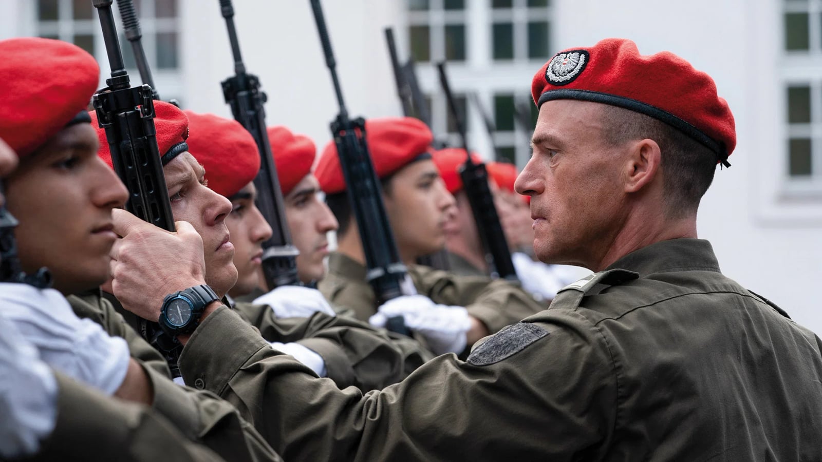 Vizeleutnant Eismayer in Uniform blickt ernst zur Seite, im Hintergrund verschwommen militärisches Umfeld