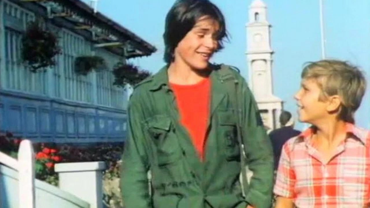Ein junger Junge in blauer Jeans blickt nachdenklich zur Seite, Szenenbild aus dem französischen Jugendfilm Erste Versuchungen von 1977