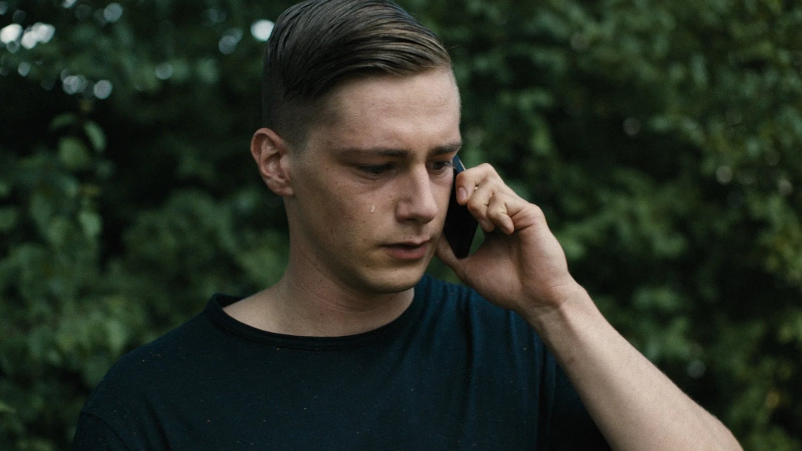 Zwei junge Männer in einer Jugend-Besserungsanstalt, einer blickt intensiv zur Seite, Szene aus Konsequenzen (2018)